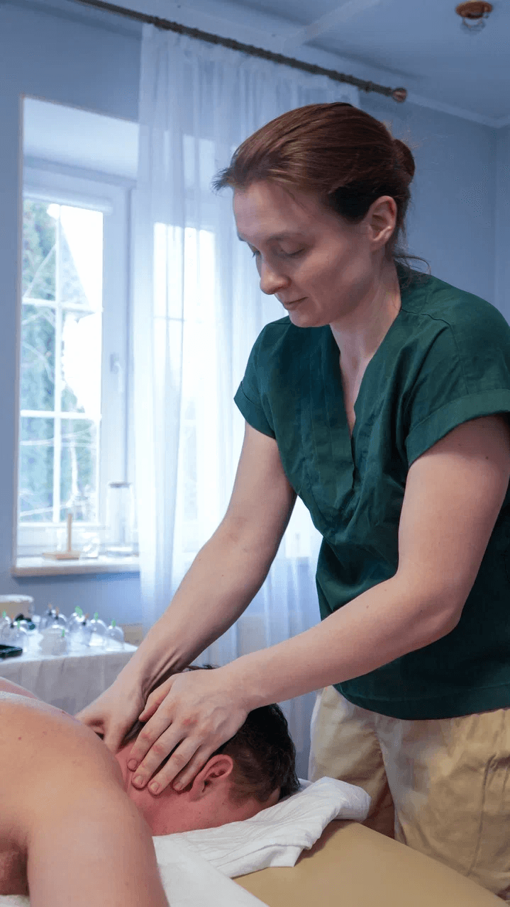 person massaging the back of a woman